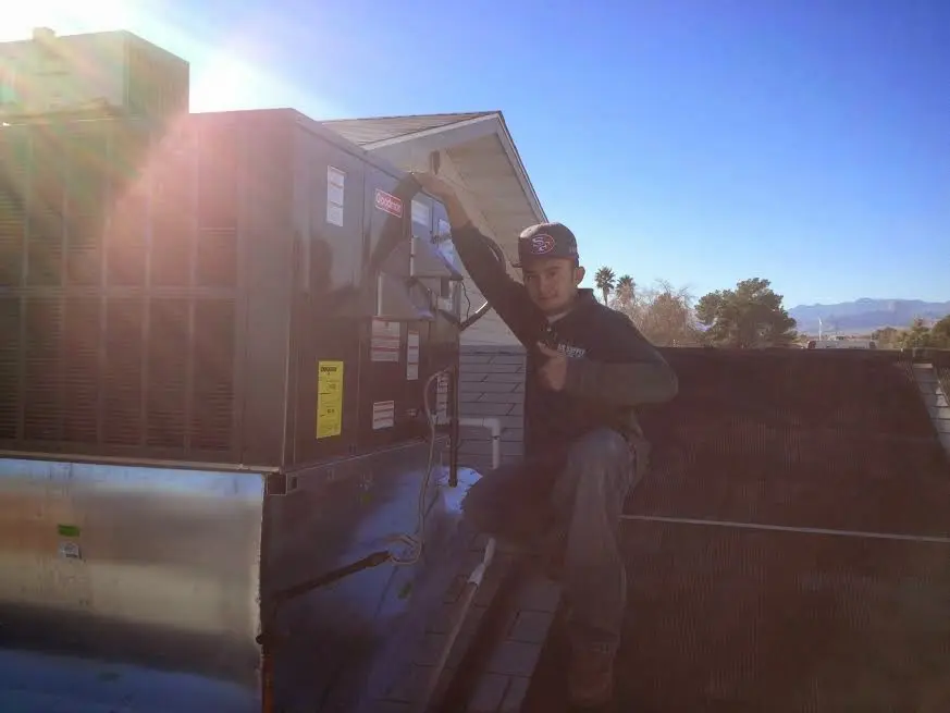 HVAC technician performing Boiler Repair on a rooftop unit in Williamstown